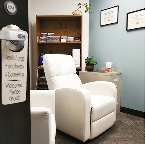 Counselling room with two white lounge chairs and blue walls