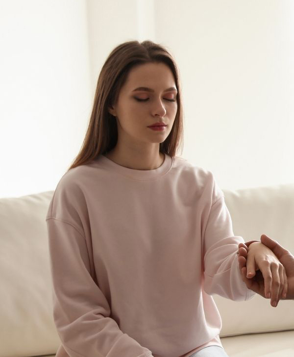 Young woman at a hypnotherapy session sitting on a white couch