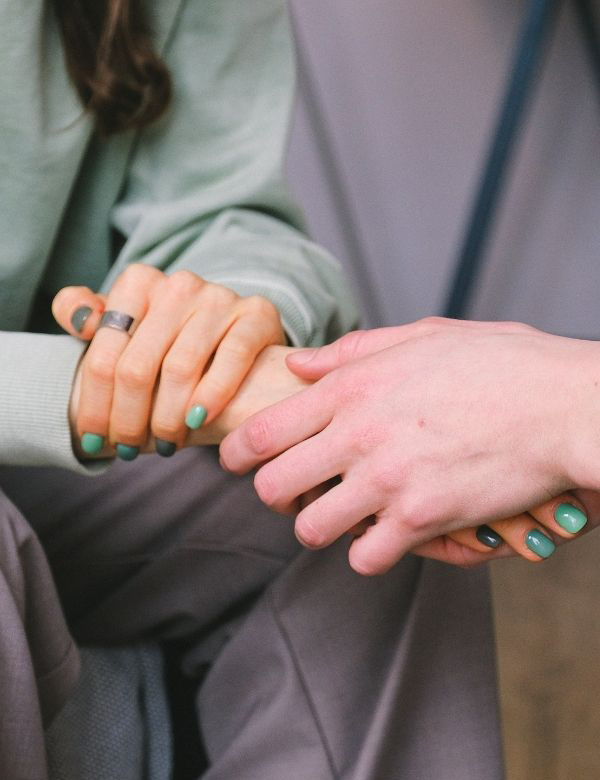 Close up of hand holding in a comforting therapist way