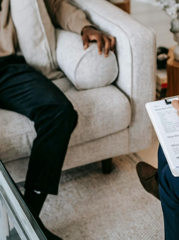 Close up of a man's legs sitting on the couch in a therapy session